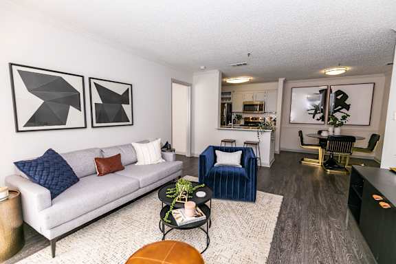 a living room with a couch and two chairs at Briarcliff Apartments, Atlanta