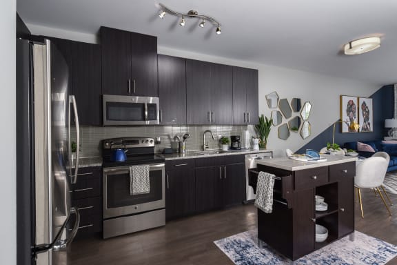 a kitchen with dark cabinets and stainless steel appliances at Heights at Glen Mills, Glen Mills Pennsylvania