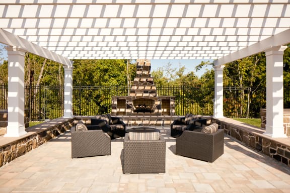 a pergola over a patio with furniture and a fireplace  at Heights at Glen Mills, Glen Mills, PA 19342
