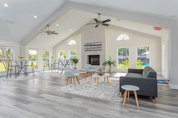 A spacious living room with a fireplace and a ceiling fan.