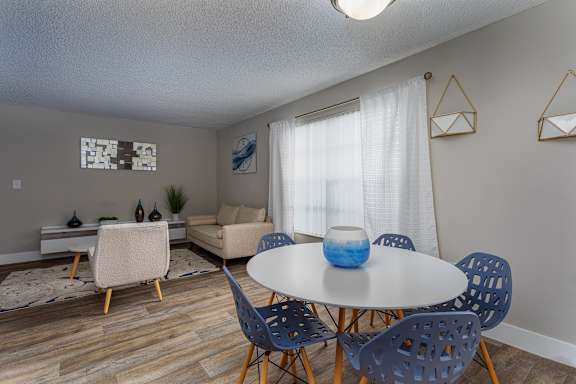 A dining room with a white table and blue chairs.