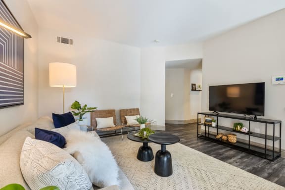 a living room with a couch and a tv at Mirasol Apartments, Las Vegas
