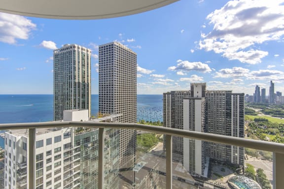 a balcony with a view of a city and a body of water at Shoreham and Tides, Chicago Illinois