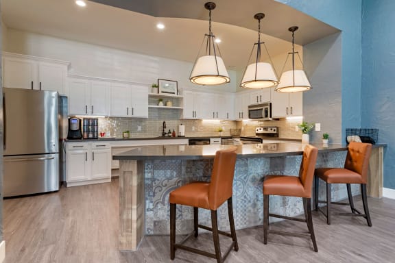 a kitchen with a large island with three chairs at Summerwind, Texas