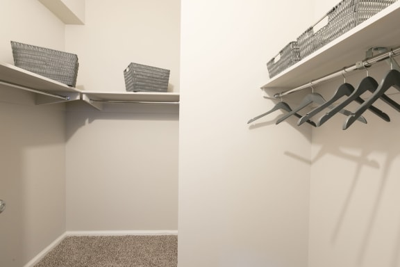 a walk in closet with chairs and a shelf on the wall at Apartments at Denver Place, Denver, CO