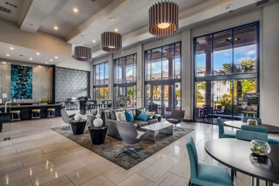a lobby with chairs and tables and large windows at Volare at the Woodlands, The Woodlands