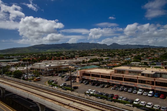 an aerial view of a city with train tracks and a building at Waikele Towers Apartments, Waipahu, Hawaii