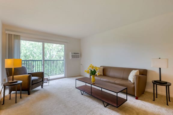 a living room with a couch and a chair and a table at Willow Hill Apartments, Justice