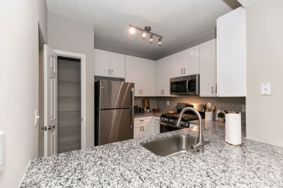 a kitchen with granite counter tops and a stainless steel refrigerator at Willowest in Collier Hills, Atlanta, 30318