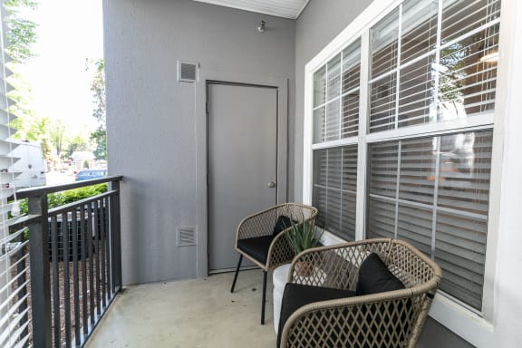 a balcony with two wicker chairs and a door to a patio at Willowest in Lindbergh, Atlanta, GA