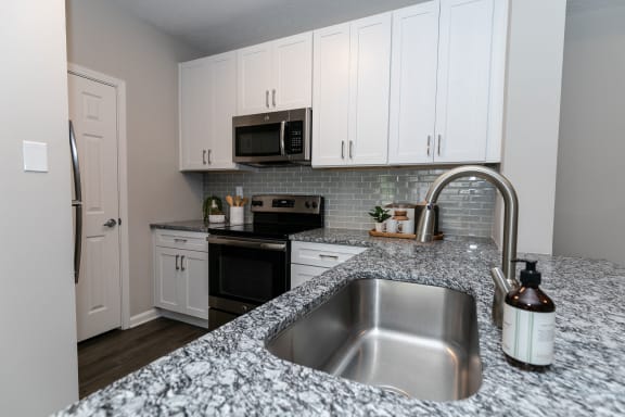 a kitchen with granite counter tops and white cabinets at Willowest in Vinings, Atlanta, GA, 30339