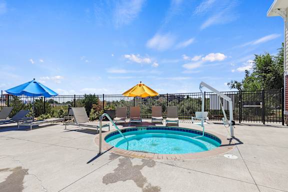 our resort style swimming pool is next to the patio and umbrellas at Ridge at Thornton Station Apartments, Thornton, 80229