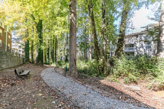 a path through the woods with a bench and a building at Roswell Village, Georgia, 30075