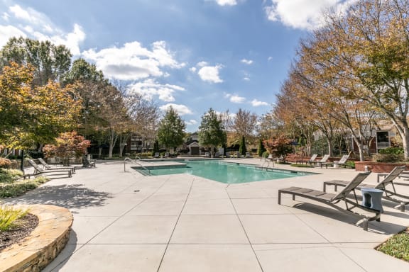pool and spa with trees and chairs around it at Roswell Village, Roswell