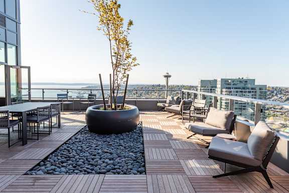 A patio with a table, chairs, and a tree.