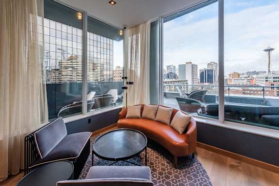 A living room with a view of the cityscape outside the large window.