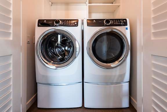 Two front loading washing machines in a laundry room.