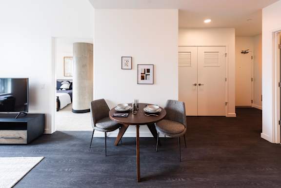 A modern dining room with a table set for two.