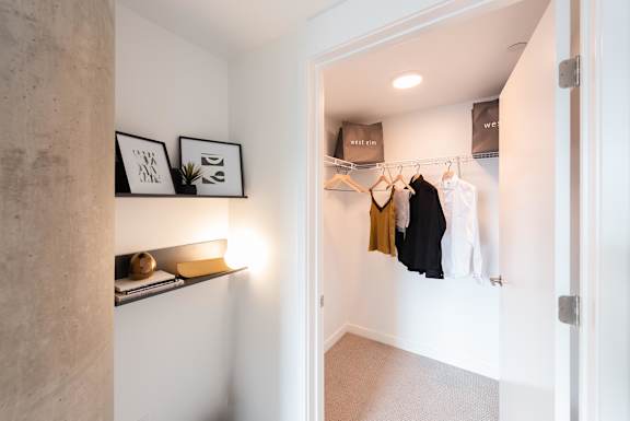 A hallway with a coat rack and a few items on a shelf.