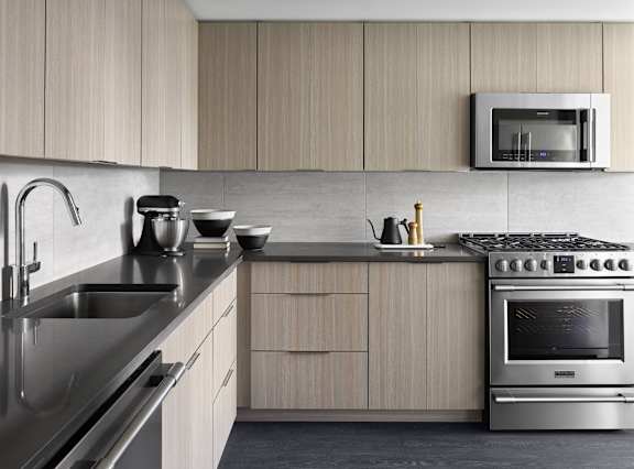 A modern kitchen with a stainless steel sink and a stove top oven.