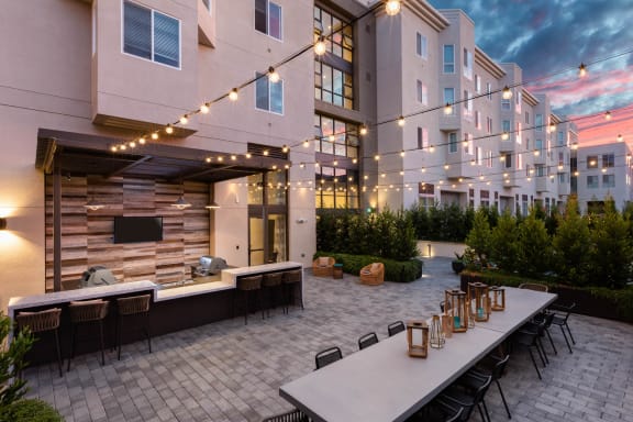 a patio with a bar and tables in front of an apartment building at Aventine, Hercules, CA, 94547