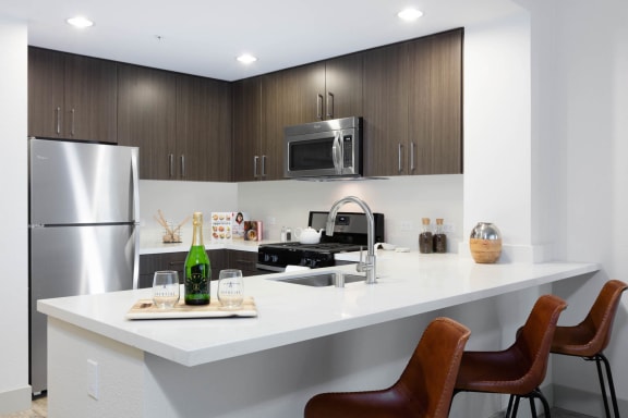a kitchen with a counter top and a refrigerator at Aventine, California