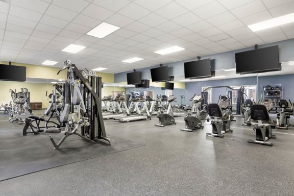 a gym with a variety of weights and cardio equipment at Veranda at Centerfield in Texas 77070