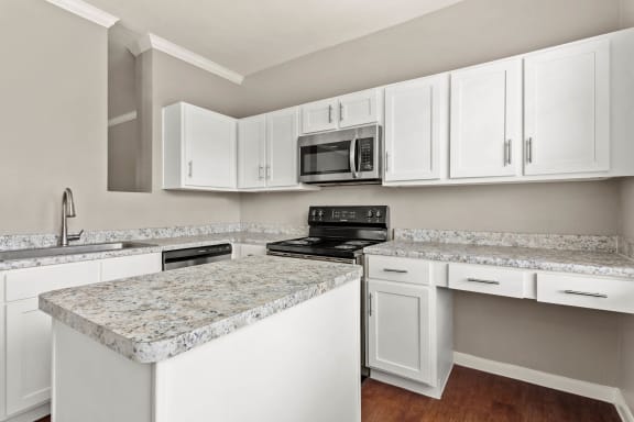 a kitchen with white cabinets and granite counter tops at Villages of Cypress Creek, Houston, Texas