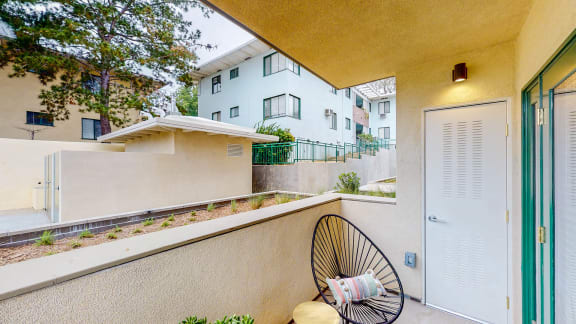 a balcony with a chair and a fan at Chase Knolls, Sherman Oaks, 91423