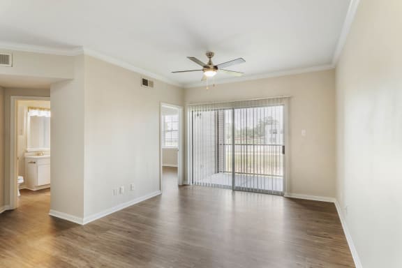 an empty living room with a ceiling fan and a large window at Villages of Cypress Creek, Houston, Texas