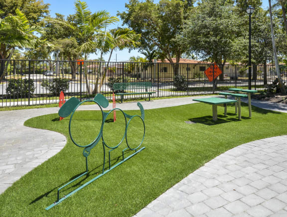 a dog park with a bench and a picnic table at District West Gables, Florida, 33155