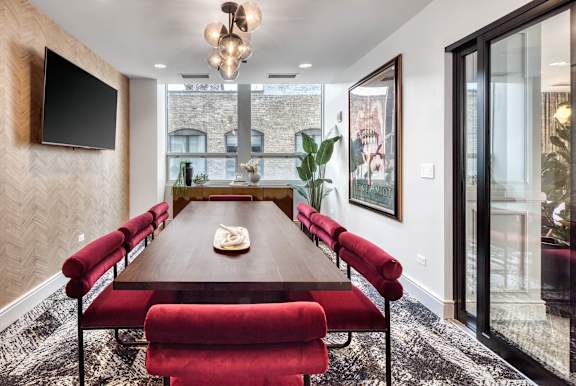 long wooden table with red chairs at Flair Tower Apartments, Illinois