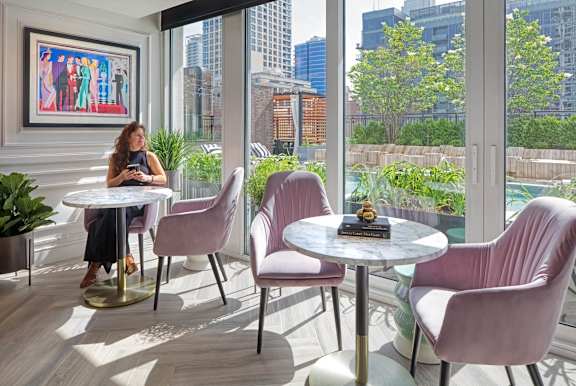 woman is sitting at a table at Flair Tower Apartments, Chicago, IL 60654