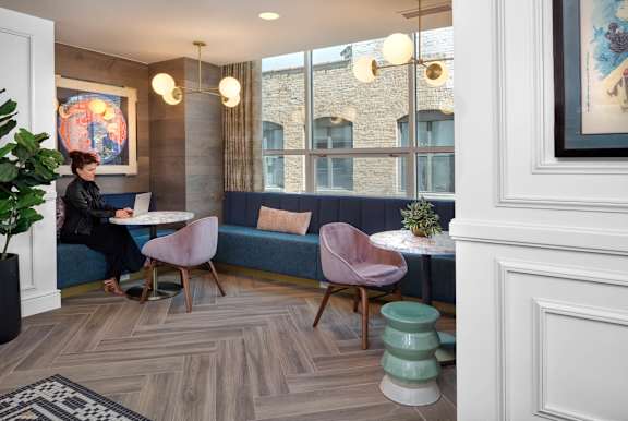 woman is sitting at blue couch at Flair Tower Apartments, Illinois, 60654