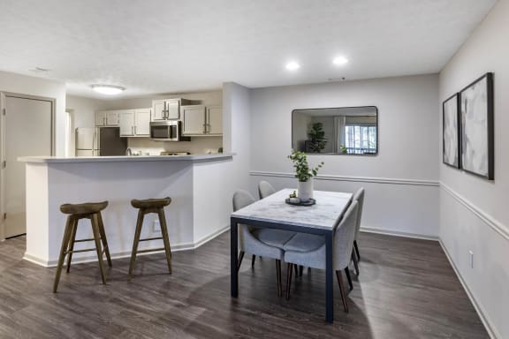a dining room and kitchen with a table and stools  at Gwinnett Pointe, Norcross, GA