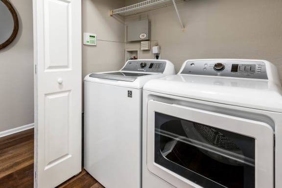 a washer and dryer in a laundry room with a door  at The Links at Plum Creek, Castlerock, Colorado
