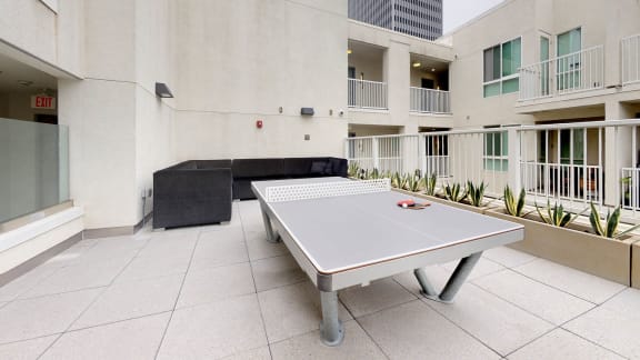 a ping pong table on the patio of an apartment building at Delphine on Diamond, California, 94131