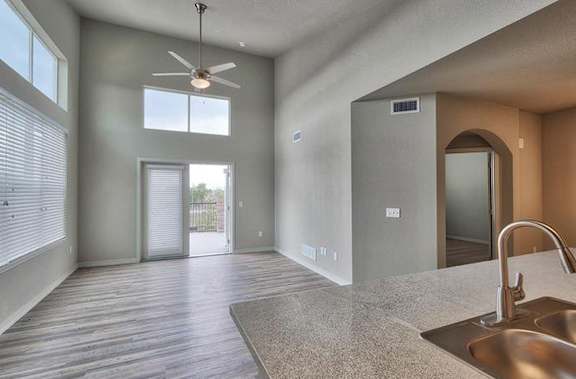 an empty kitchen and living room with a ceiling fan at Ridge at Thornton Station Apartments, Thornton, CO