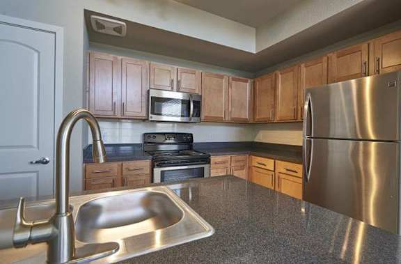 a kitchen with stainless steel appliances and a sink at Ridge at Thornton Station Apartments, Thornton, CO 80229
