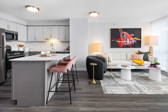 a living room with a kitchen in the background and a couch and coffee table in the foreground at Shoreham and Tides, Chicago, 60601