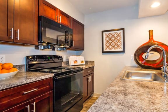 a kitchen with black appliances and granite counter tops at Skyview Apartments, Westminster