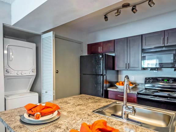 full kitchen with stainless steel appliances and granite counter tops and a sink at Skyview Apartments, Colorado