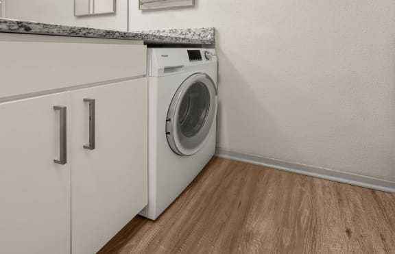 a front loading washer and dryer in a laundry room with a counter top at South Lamar Village in Austin, TX 78704