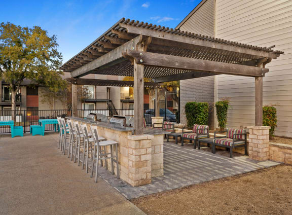 a patio with a bar and chairs in front of a house at South Lamar Village in Austin, Texas 78704