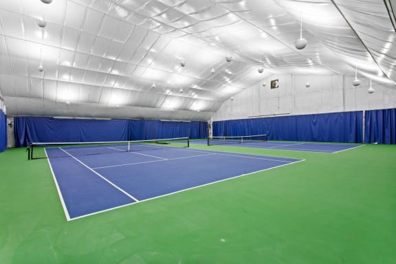 a tennis court in a gym with a blue and green court at The Annaline, Tennessee, 37217