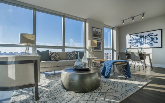a living room with large windows and a couch and a table at The Elle Apartments, Chicago, Illinois