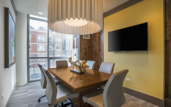 a dining room with a table and chairs and a tv at The Elle Apartments, Chicago