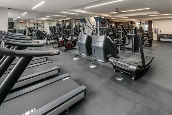 a gym with cardio equipment and weights on the floor at The Grand Central, Chicago