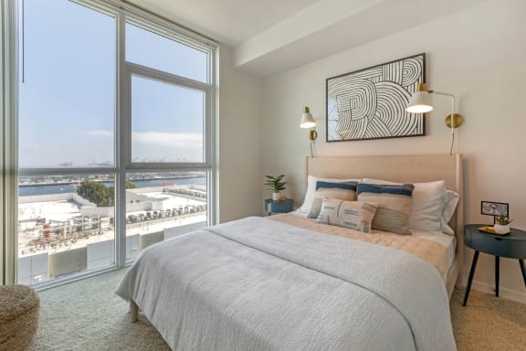 a bedroom with a bed and a large window at Vue, San Pedro, CA