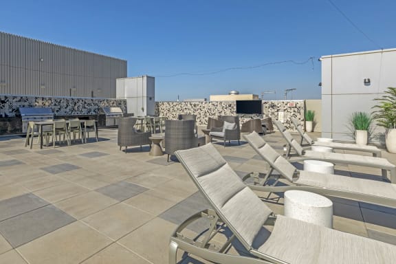 a roof top patio with lounge chairs and tables at Vue, San Pedro, CA